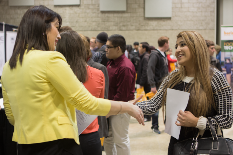 A young lady shaking hands with an employer